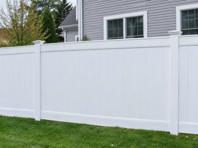 White vinyl privacy fence beside a clapboard home in Massachusetts